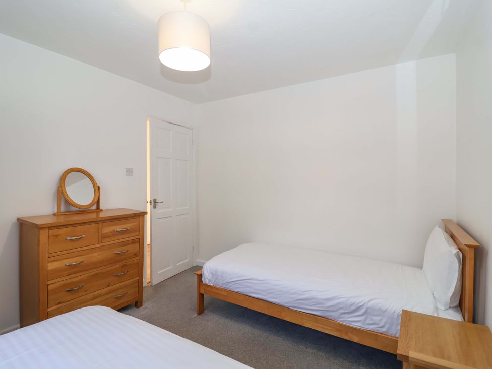 A bedroom with two beds and a dresser at Bracken Cottage in St Tudy
