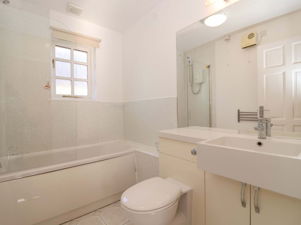 A bathroom with a bath tub and sink at Bracken Cottage St Tudy