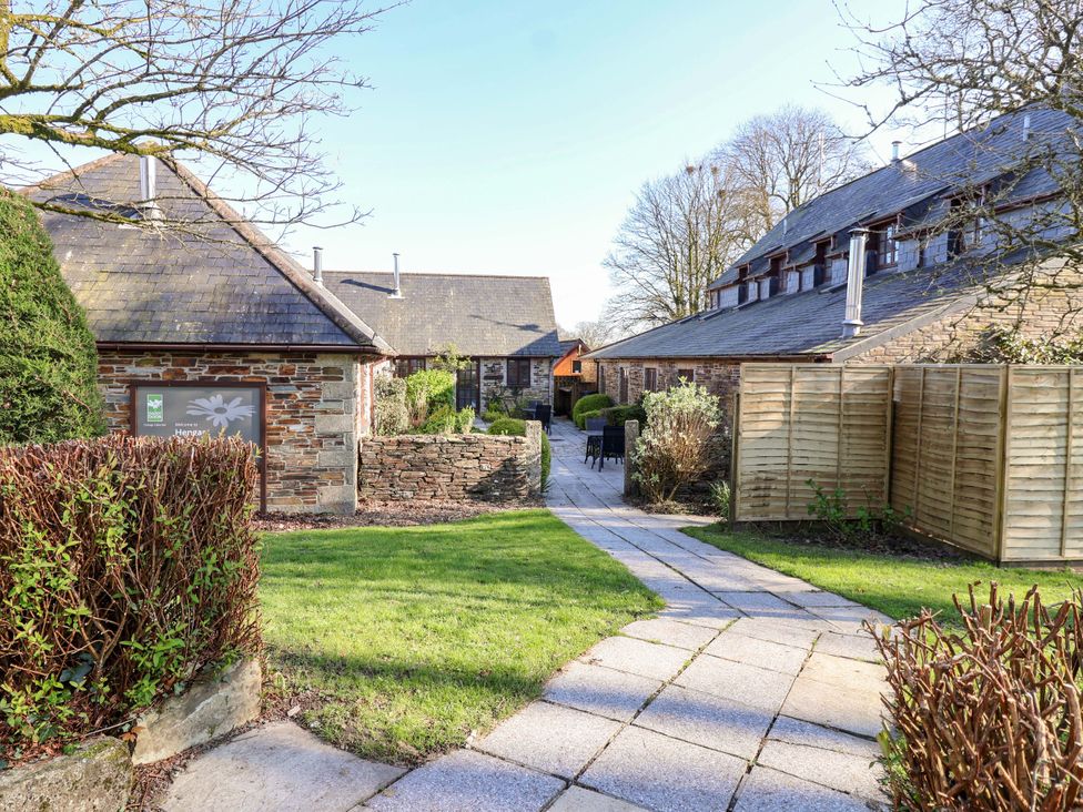 A courtyard with buildings and pathway at Bracken Cottage St Tudy