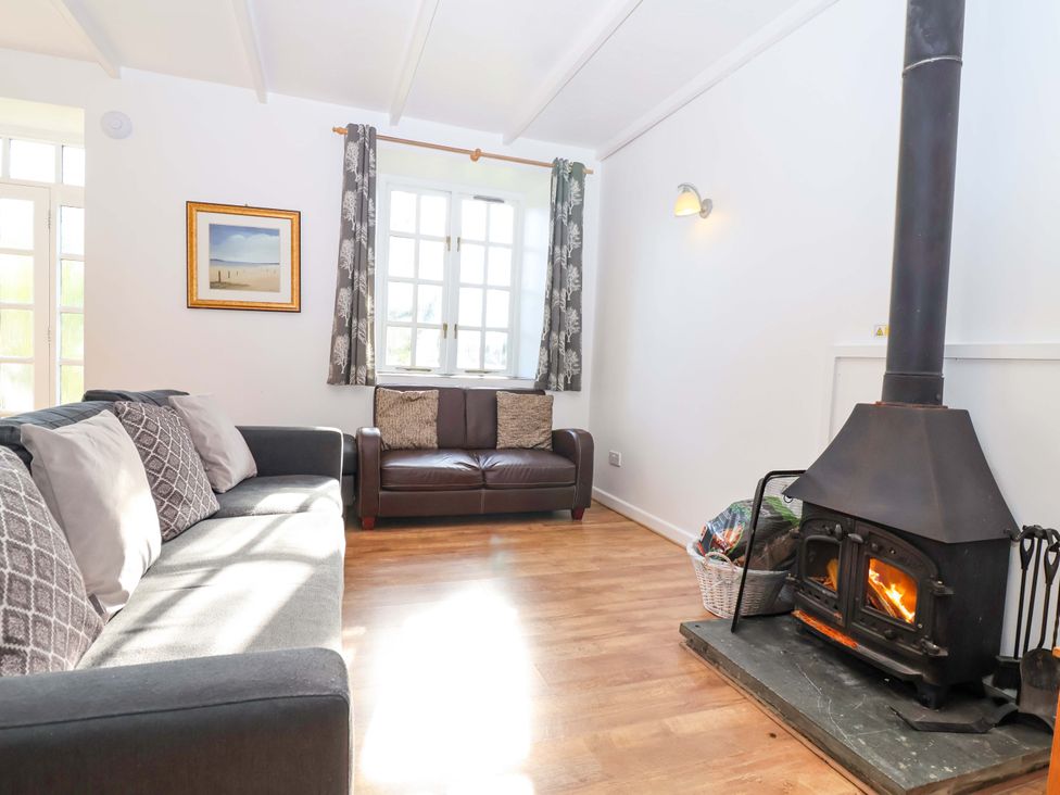 A living room with a fireplace and two sofas at Roughtor Cottage St Tudy