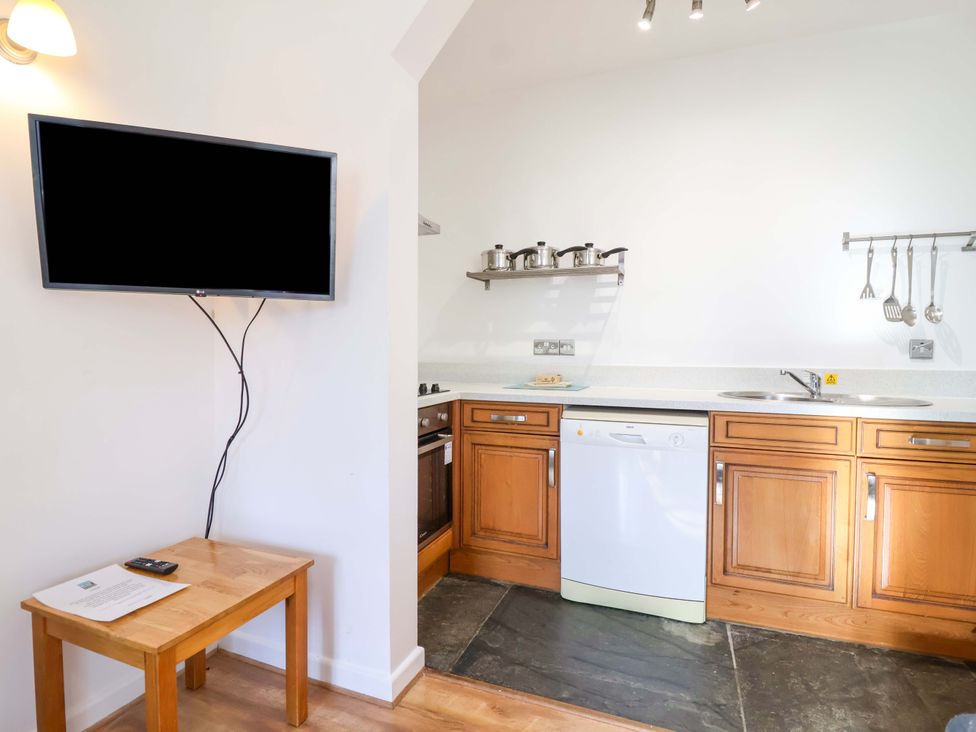 A kitchen with a television and dishwasher at Roughtor Cottage St Tudy