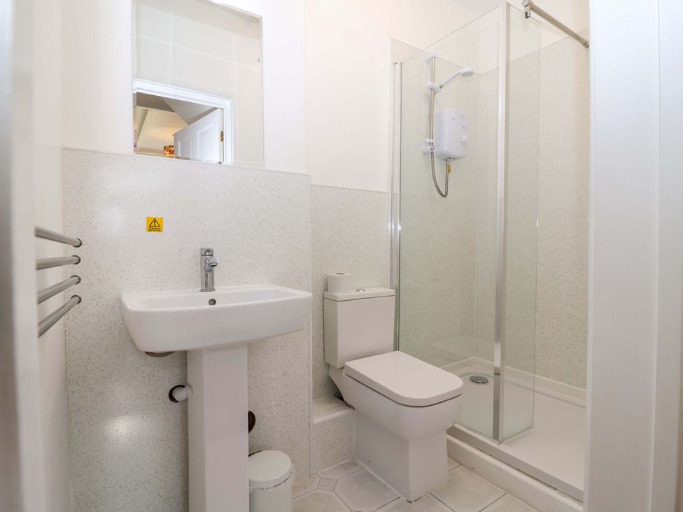 A bathroom with a sink, toilet, and shower at Roughtor Cottage St Tudy