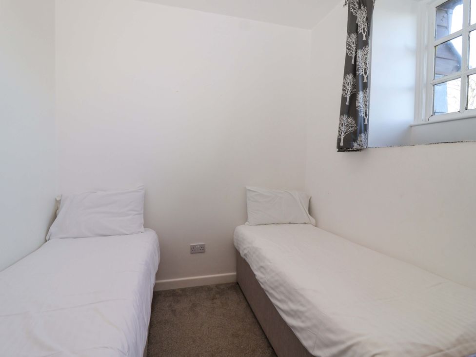 A bedroom with two single beds at Roughtor Cottage St Tudy