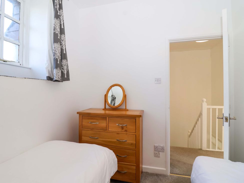 A bedroom with a chest of drawers and a mirror at Roughtor Cottage St Tudy