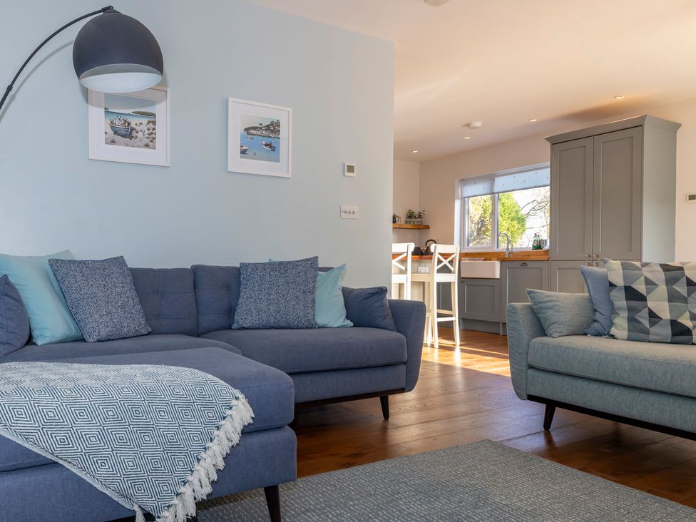 A living room with sofas and kitchen area at 38 Venn Park Stoke Fleming