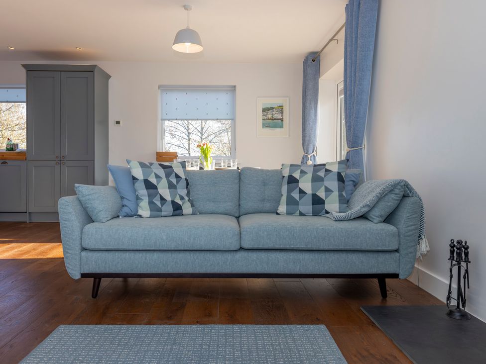 A living room with a sofa and dining area at 38 Venn Park Stoke Fleming