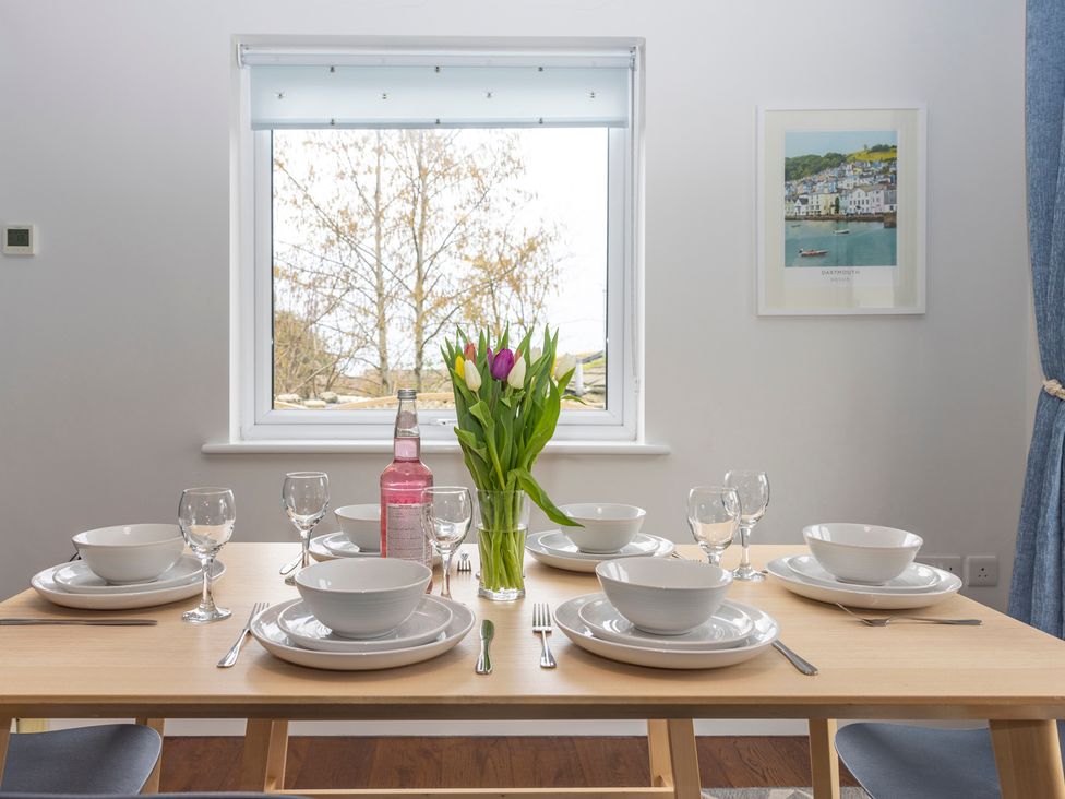 A dining room table set for a meal with flowers at 38 Venn Park Stoke Fleming