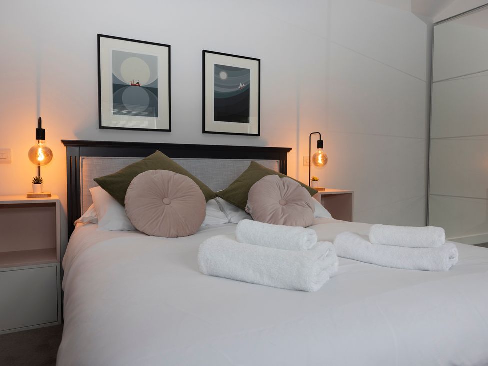 A bedroom with a bed and wall art at 38 Venn Park in Stoke Fleming