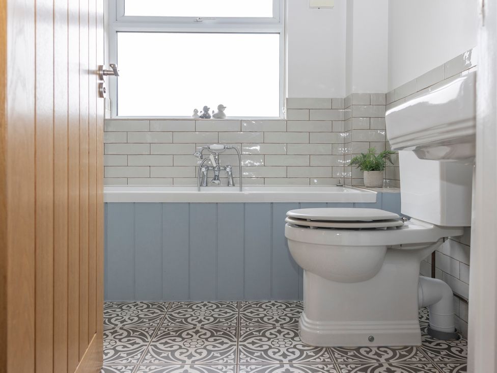 A bathroom with a bathtub and toilet at 38 Venn Park in Stoke Fleming