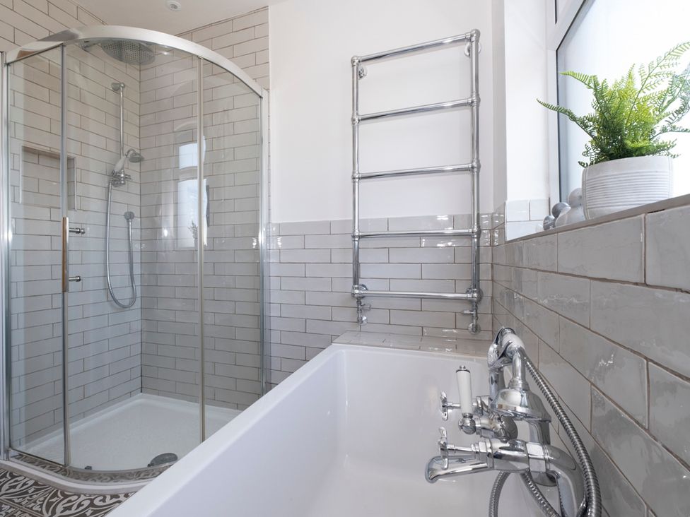 A bathroom with a shower and bathtub at 38 Venn Park in Stoke Fleming