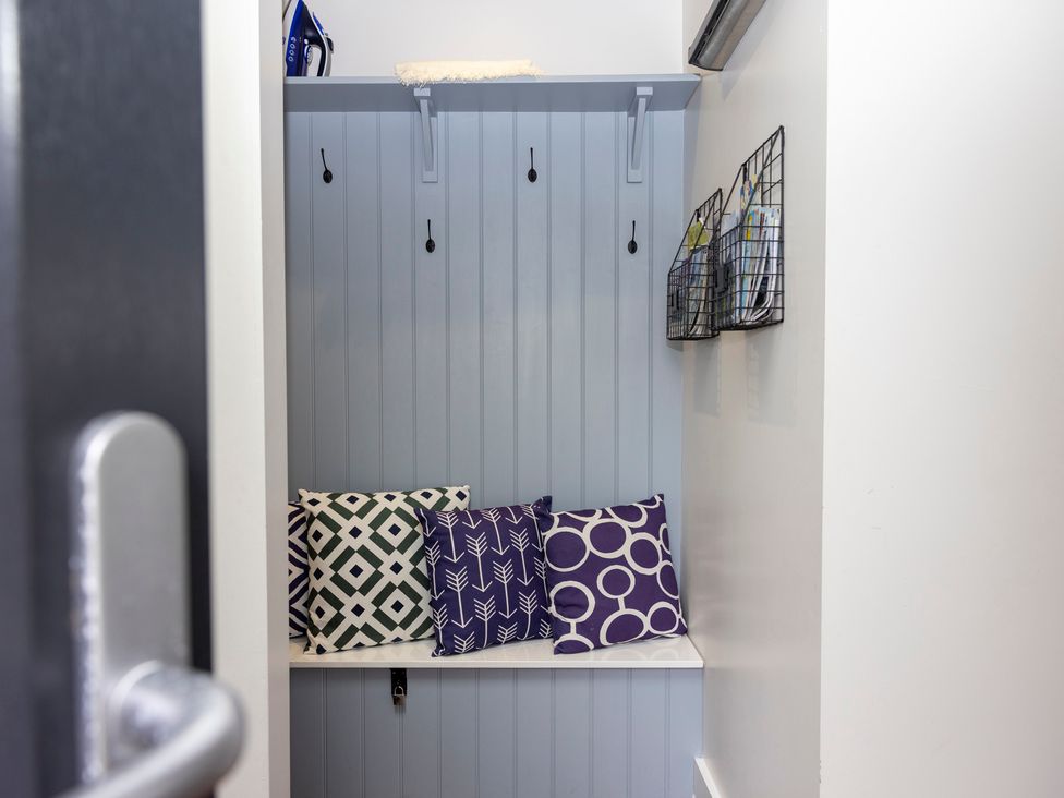 A mudroom with a bench and pillows at 38 Venn Park in Stoke Fleming