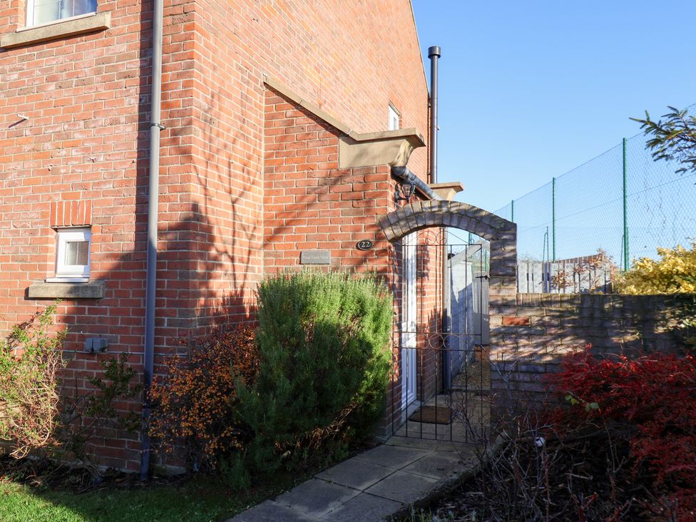 An outdoor view of a brick house entrance with a gate at Pond Farm View in Hinderwell