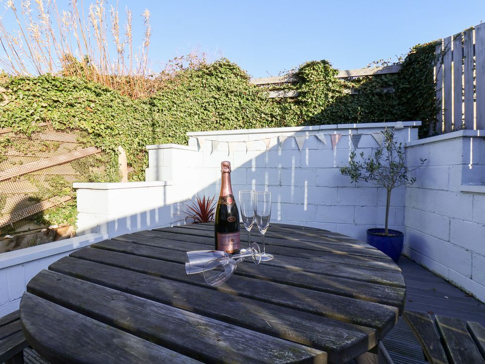 An outdoor area with a table, champagne bottle, and glasses at Pond Farm View in Hinderwell