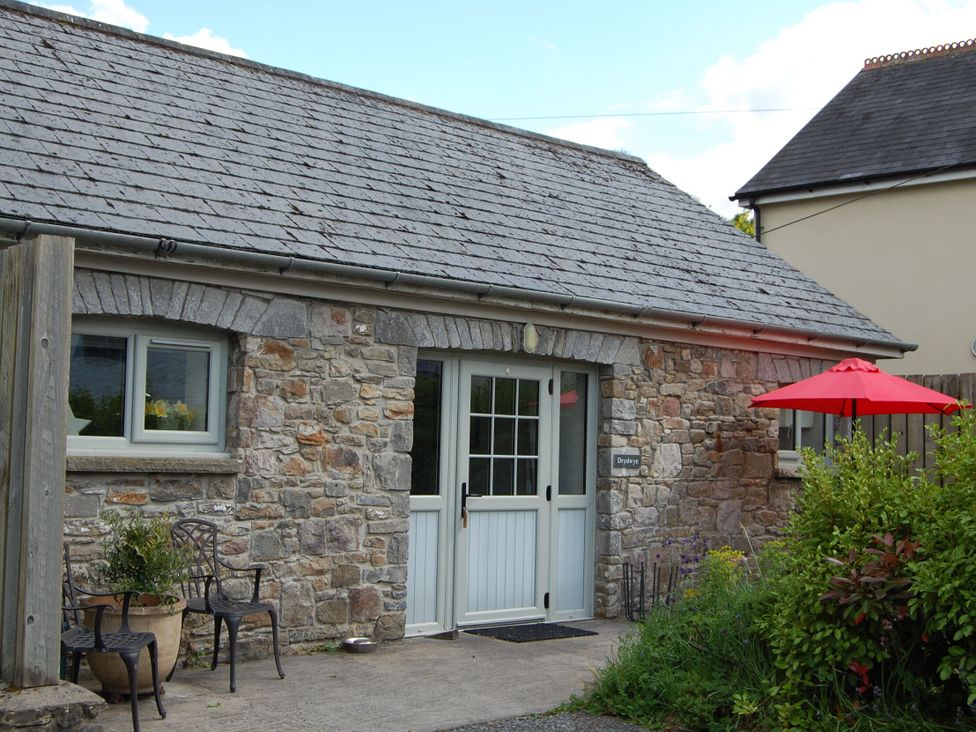 A stone cottage entrance with a table and chairs at Dryslwyn Cottage in Llandeilo