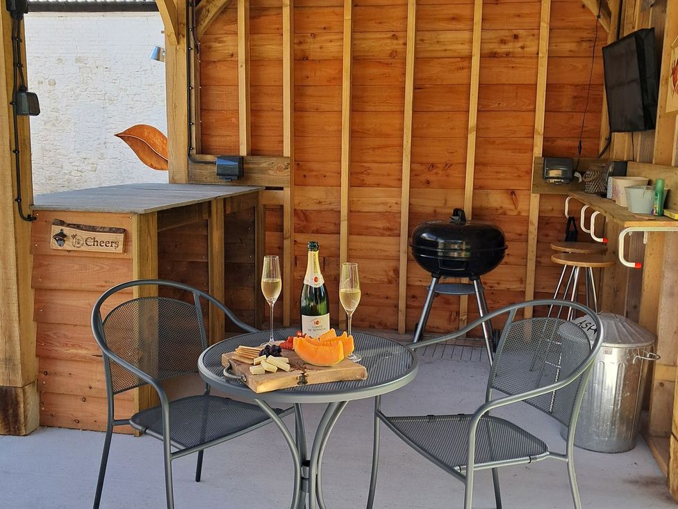 An outdoor seating area with a table and chairs at Dinefwr Cottage in Golden Grove near Llandeilo