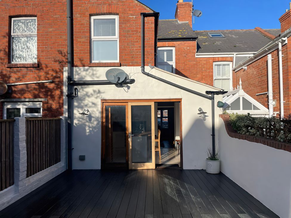 An outdoor area with a door and windows at Owl's Rest in Weymouth