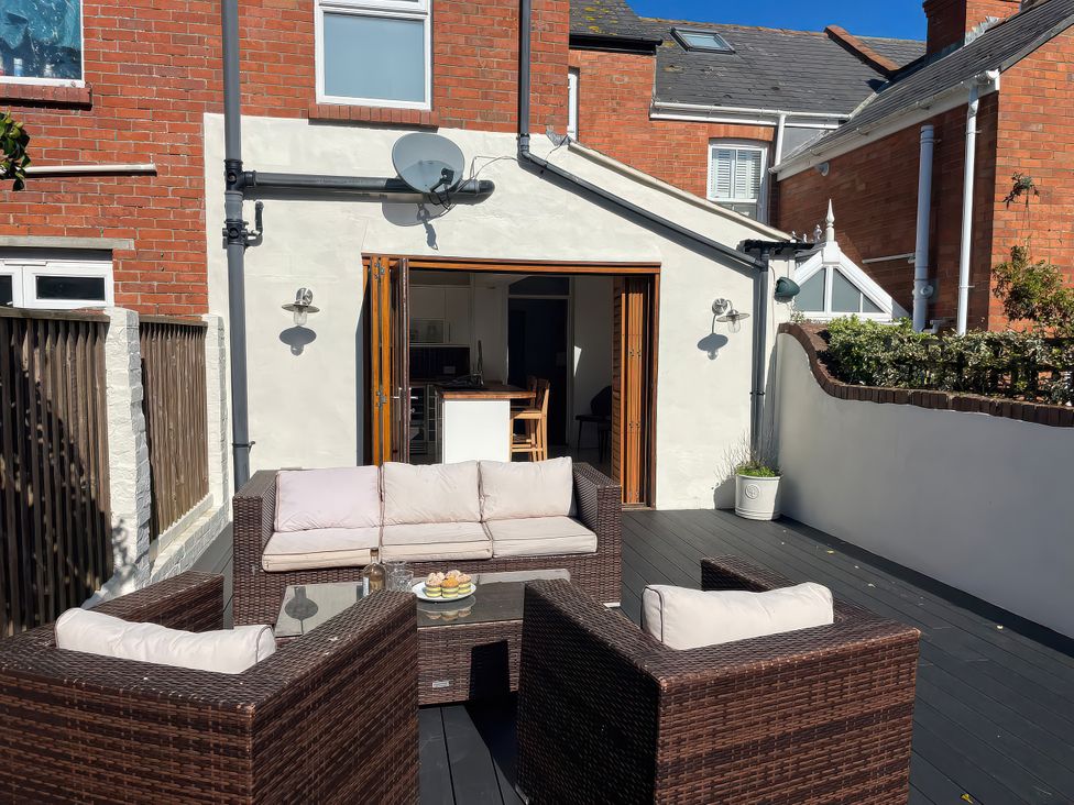 A patio with a sofa and coffee table at Owl's Rest in Weymouth