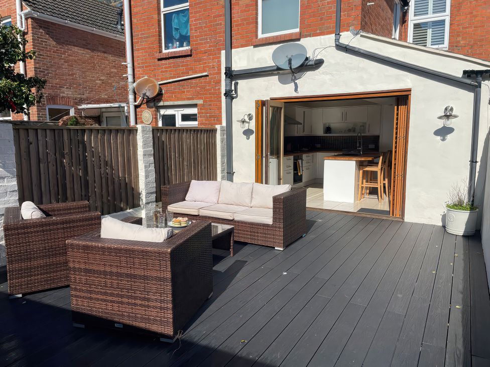 An outdoor seating area with a sofa and table at Owl's Rest in Weymouth