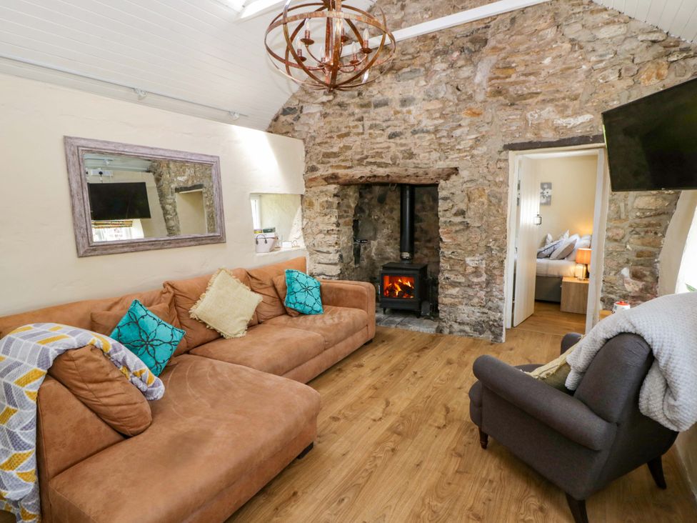 A living room with a sofa and fireplace at Cobwebs in Cold Inn near Saundersfoot