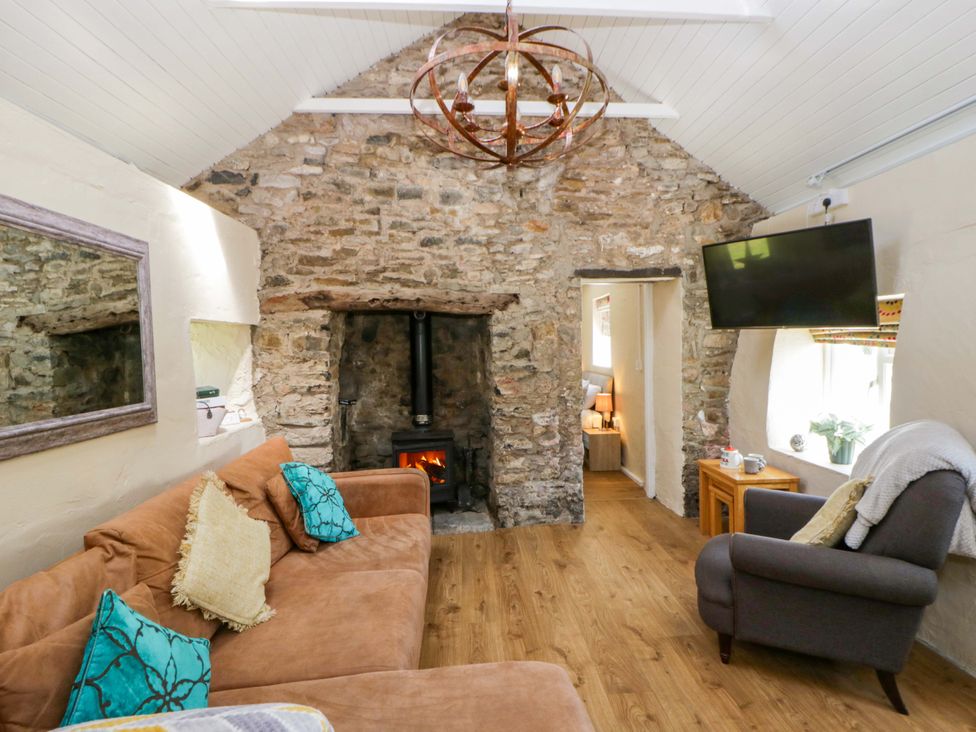 A living room with a sofa and fireplace at Cobwebs in Cold Inn near Saundersfoot