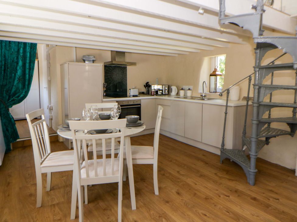 A kitchen with dining table and chairs at Cobwebs in Cold Inn near Saundersfoot