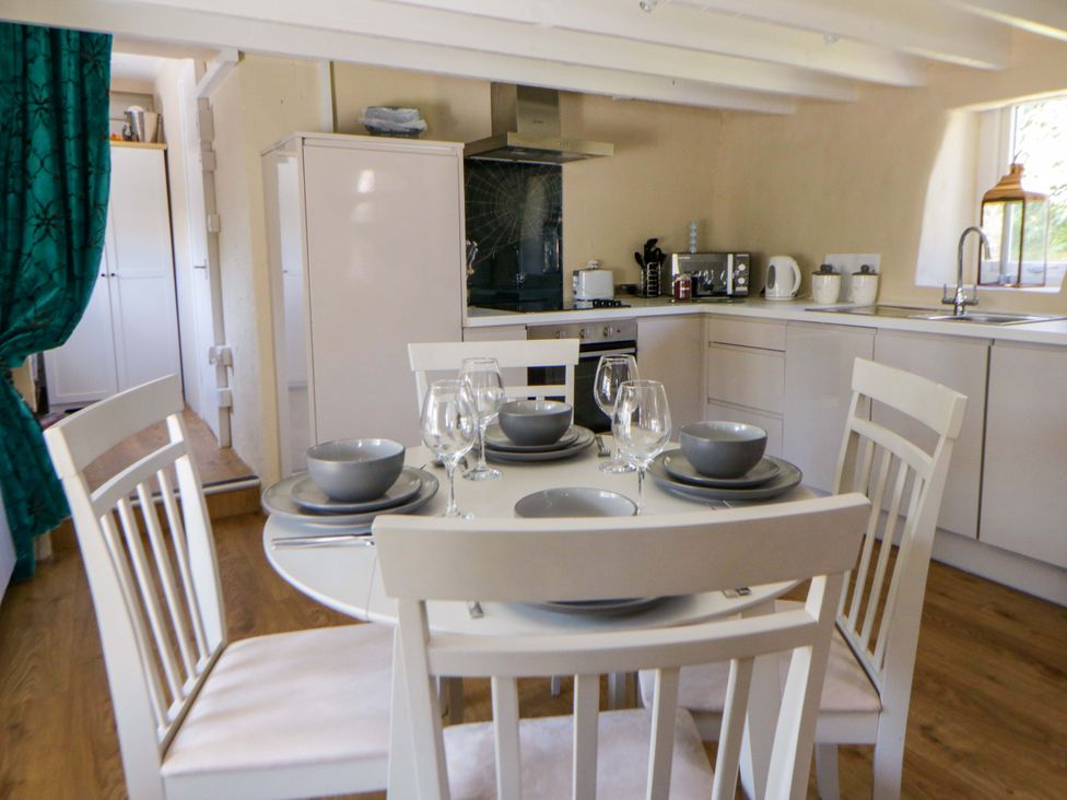 A kitchen with a dining table and chairs at Cobwebs in Cold Inn near Saundersfoot