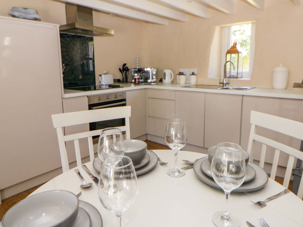 A kitchen with dining table and cookware at Cobwebs near Cold Inn Saundersfoot