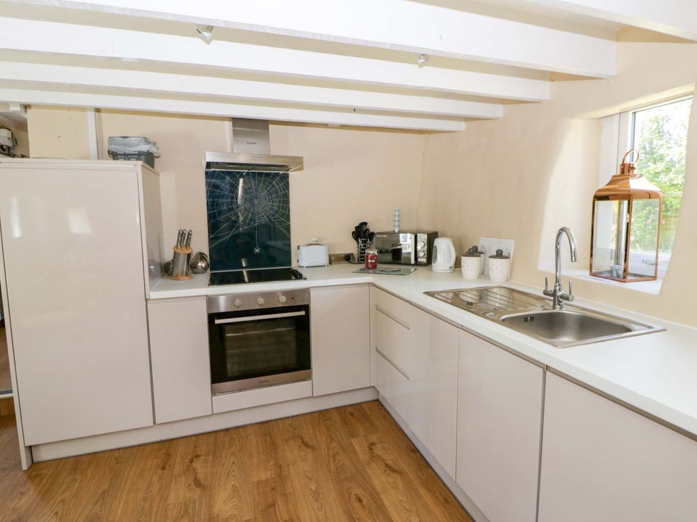 A kitchen with an oven, sink, and various appliances at Cobwebs, Cold Inn near Saundersfoot