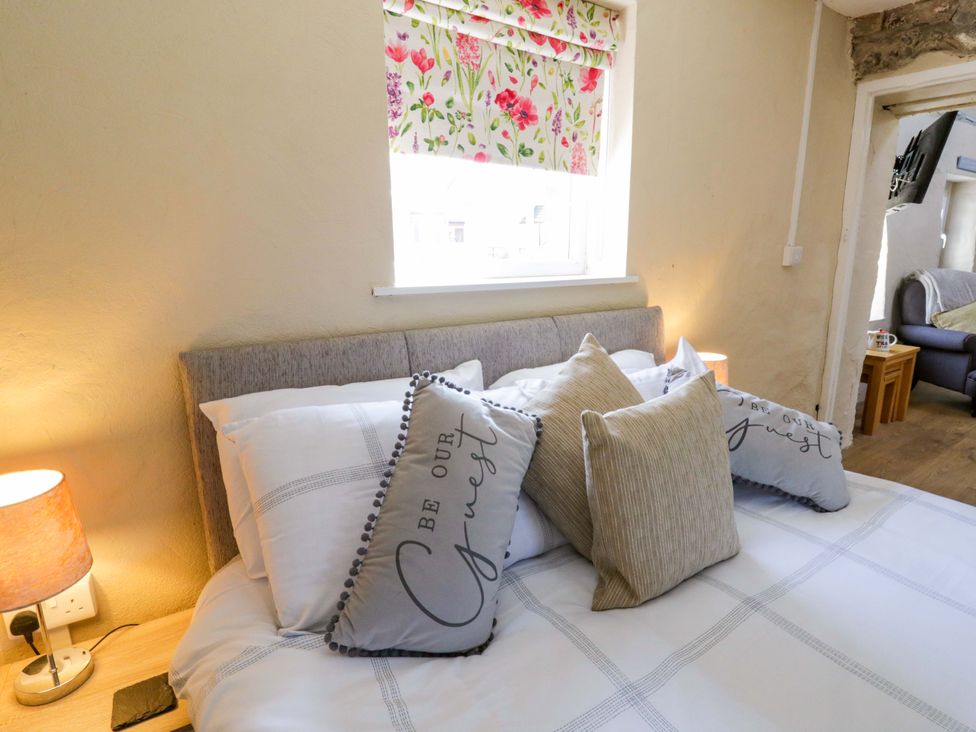 A bedroom with a bed and decorative pillows at Cobwebs in Cold Inn near Saundersfoot
