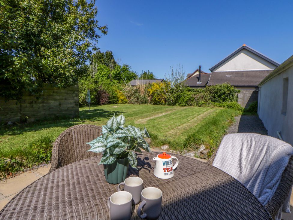 A garden with a table and chairs at Cobwebs Cold Inn near Saundersfoot