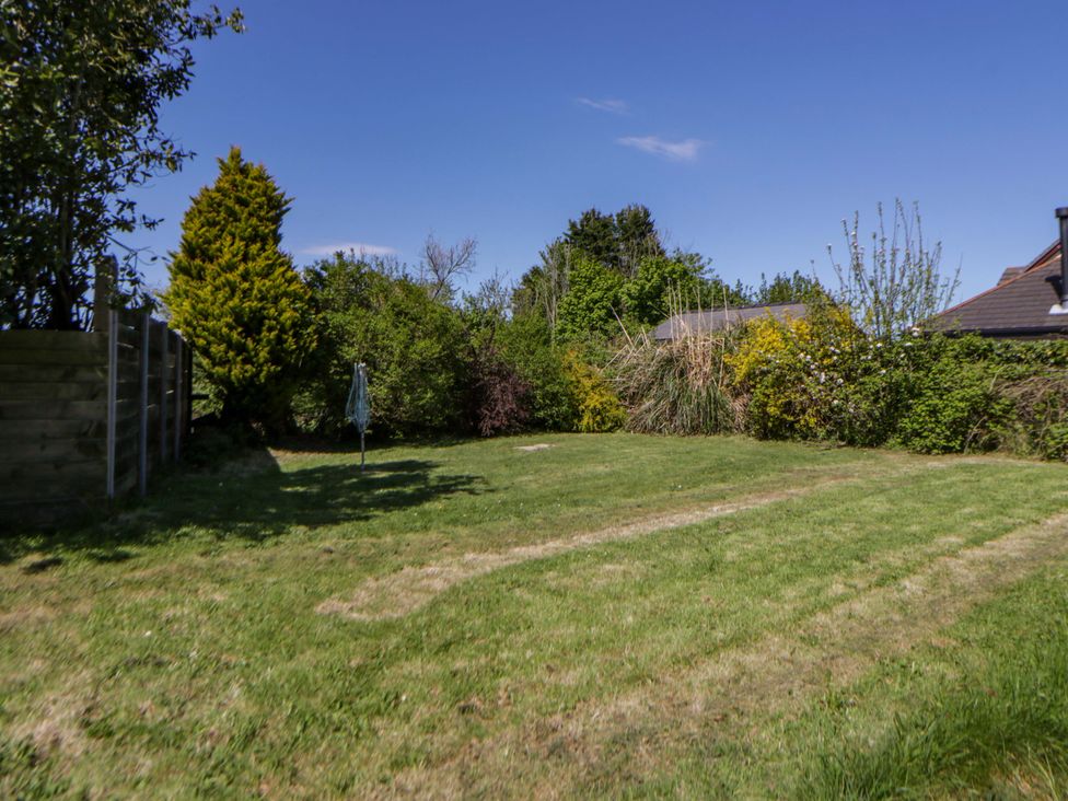 A garden with grass and trees at Cobwebs Cold Inn near Saundersfoot