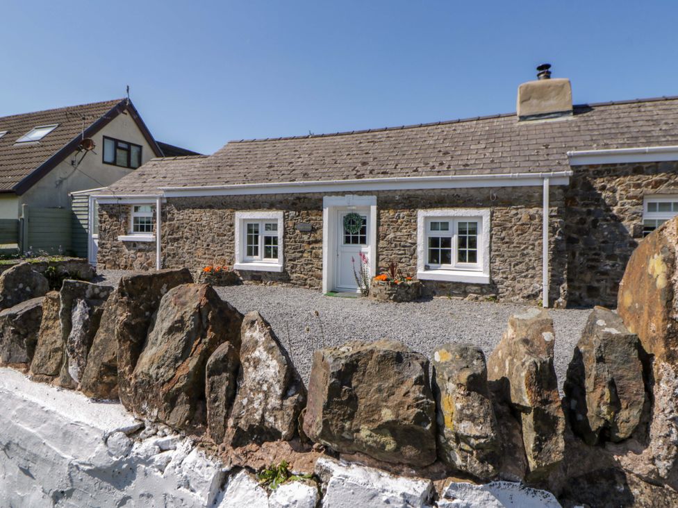 A house with a stone exterior and gravel area at Cobwebs Cold Inn near Saundersfoot