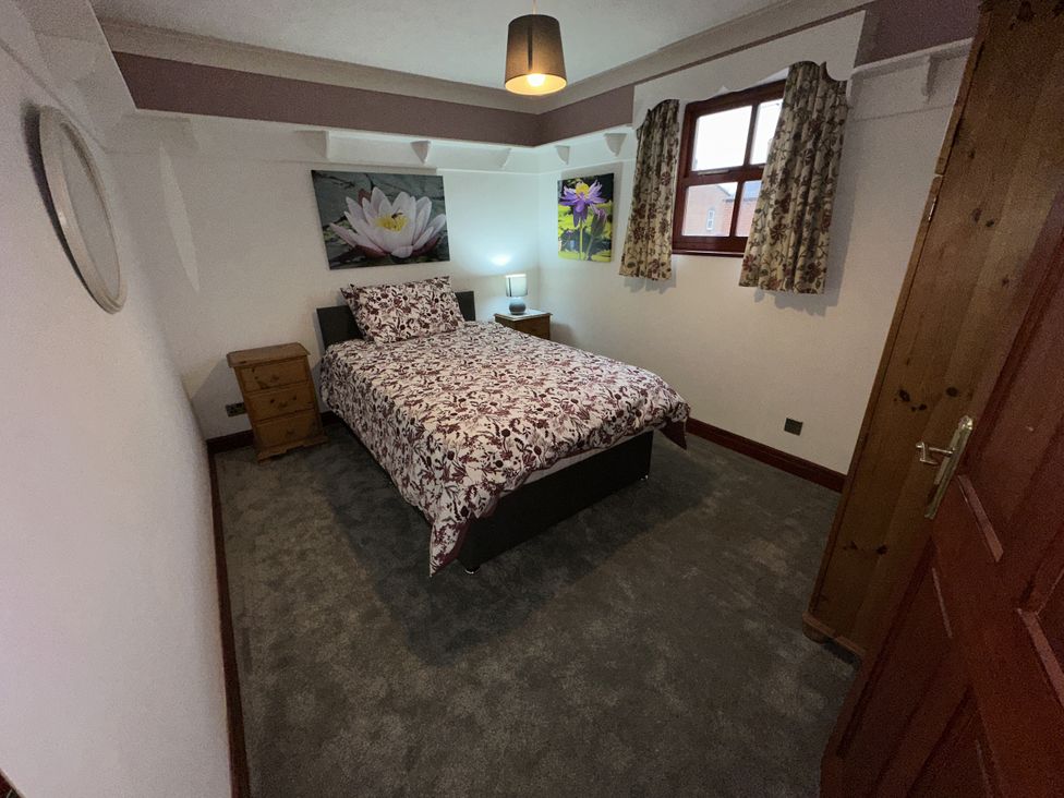A bedroom with a bed and bedside table at Eric House in Filey
