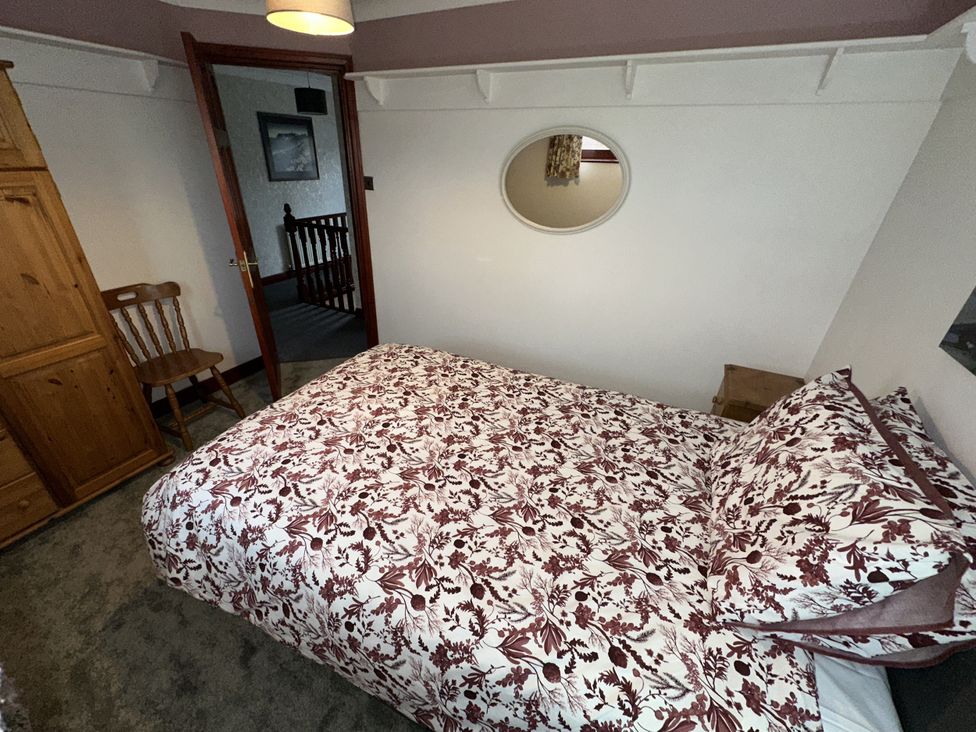 A bedroom with a bed and wardrobe at Eric House in Filey