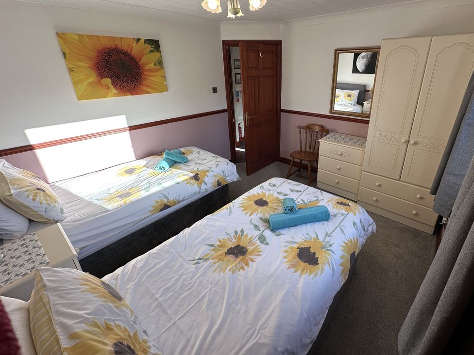 A bedroom with two beds and a wardrobe at Eric House in Filey