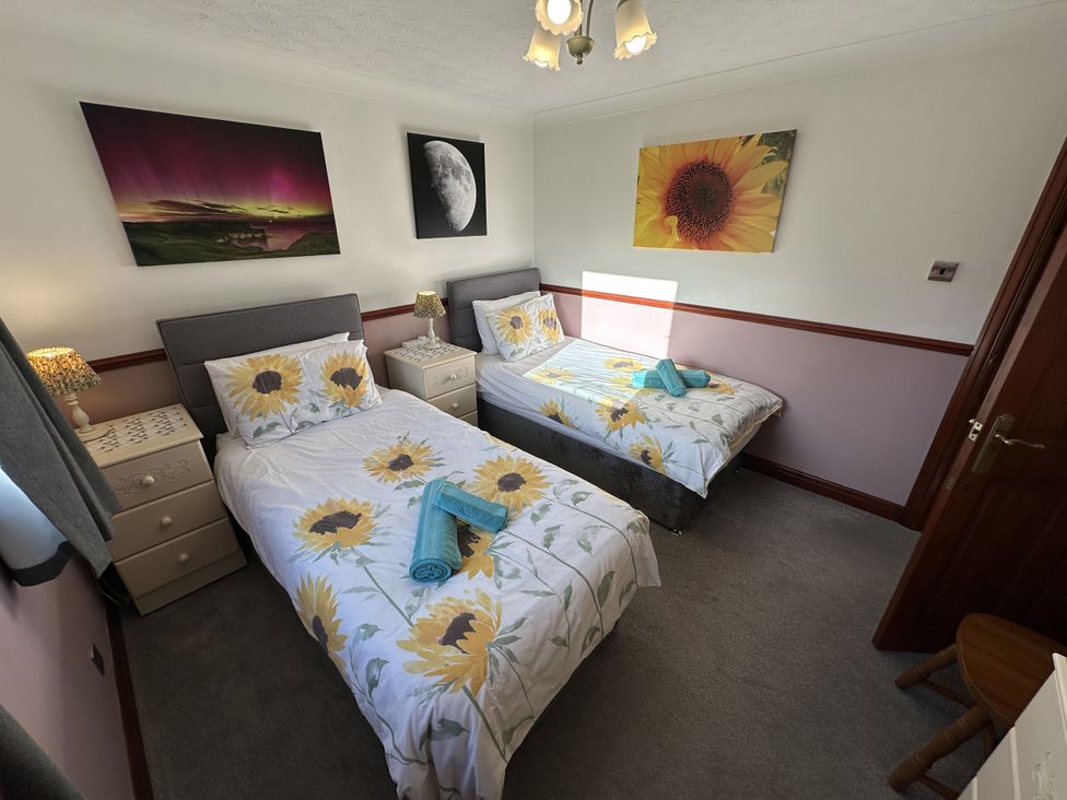 A bedroom with two beds and artwork at Eric House in Filey