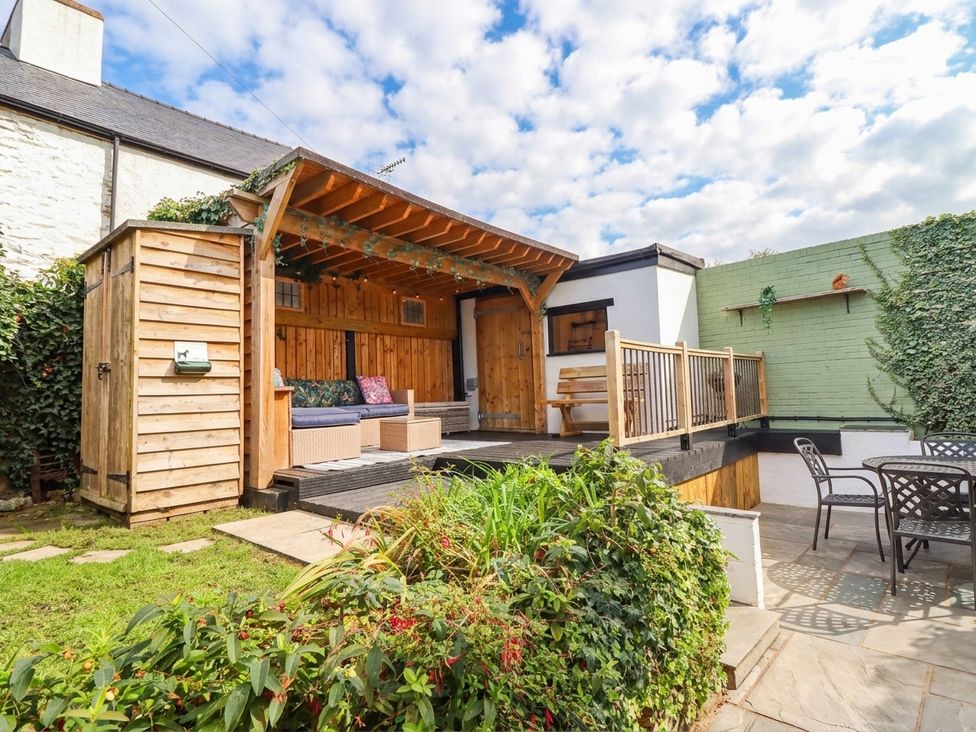 A garden with a wooden deck and seating at 18 Church Street, Llangollen