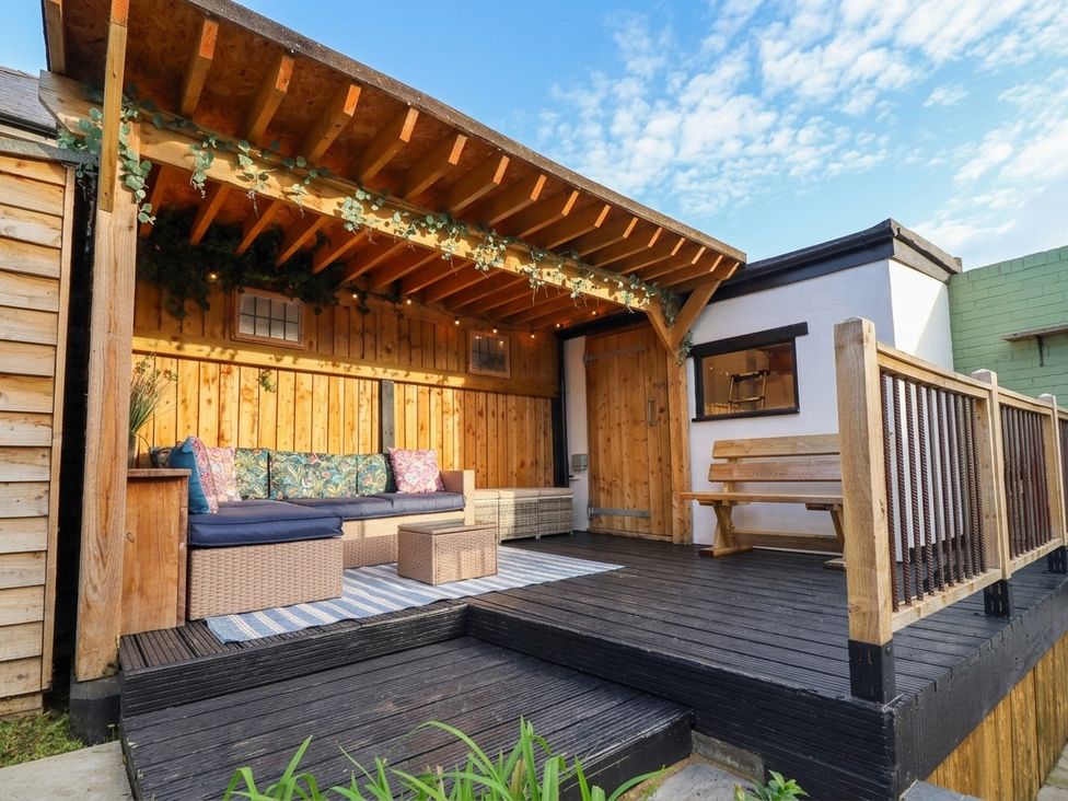 An outdoor patio with seating and a wooden deck at 18 Church Street Llangollen