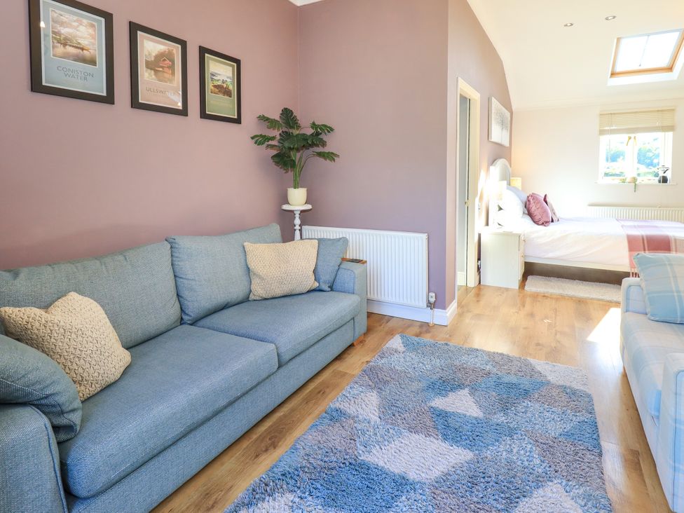 A living room with a sofa and a bed at The Garden Suite at Fiddler Hall Barn, Newby Bridge