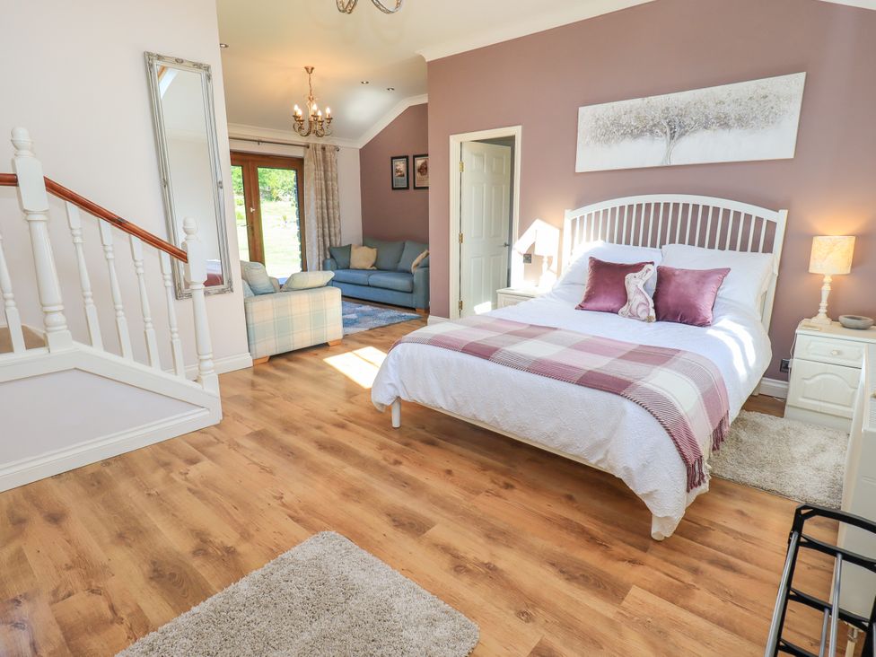 A bedroom with a bed and a sofa at The Garden Suite at Fiddler Hall Barn Newby Bridge