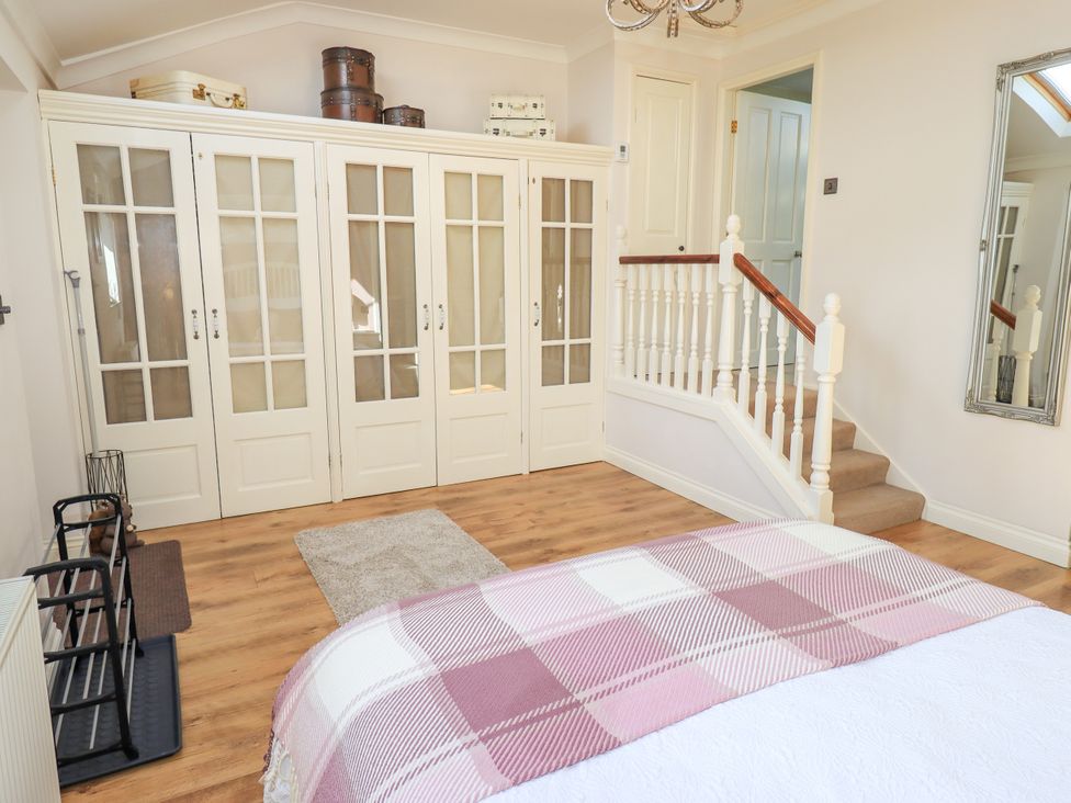 A bedroom with a wardrobe and stairs at The Garden Suite at Fiddler Hall Barn Newby Bridge