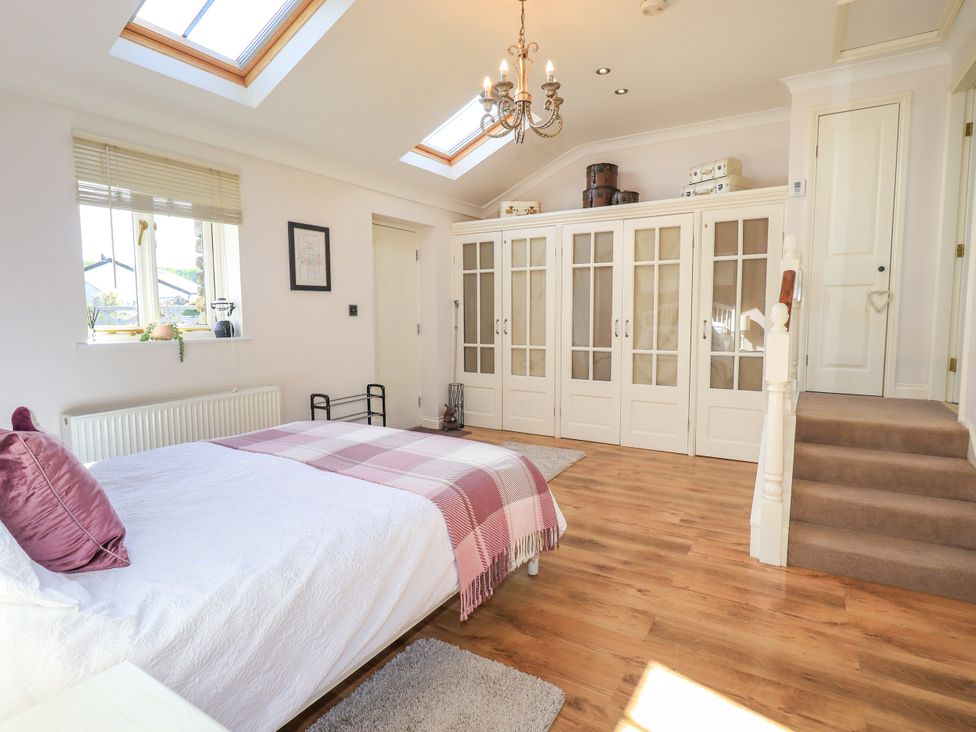 A bedroom with a bed and wardrobe at The Garden Suite at Fiddler Hall Barn Newby Bridge