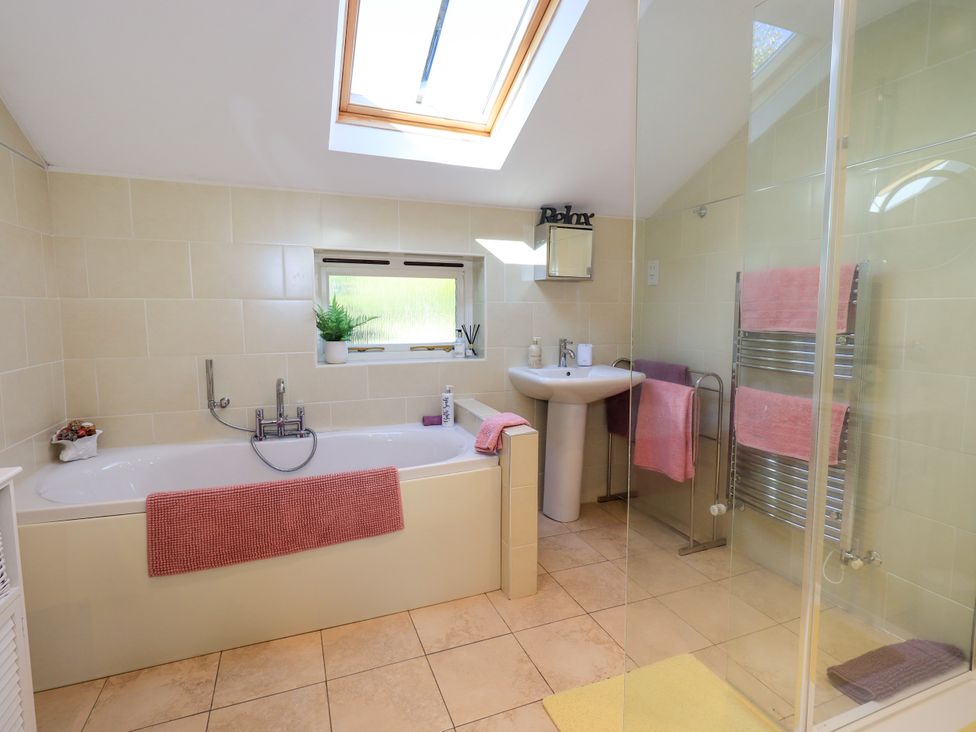A bathroom featuring a bathtub, sink, and shower at The Garden Suite at Fiddler Hall Barn, Newby Bridge