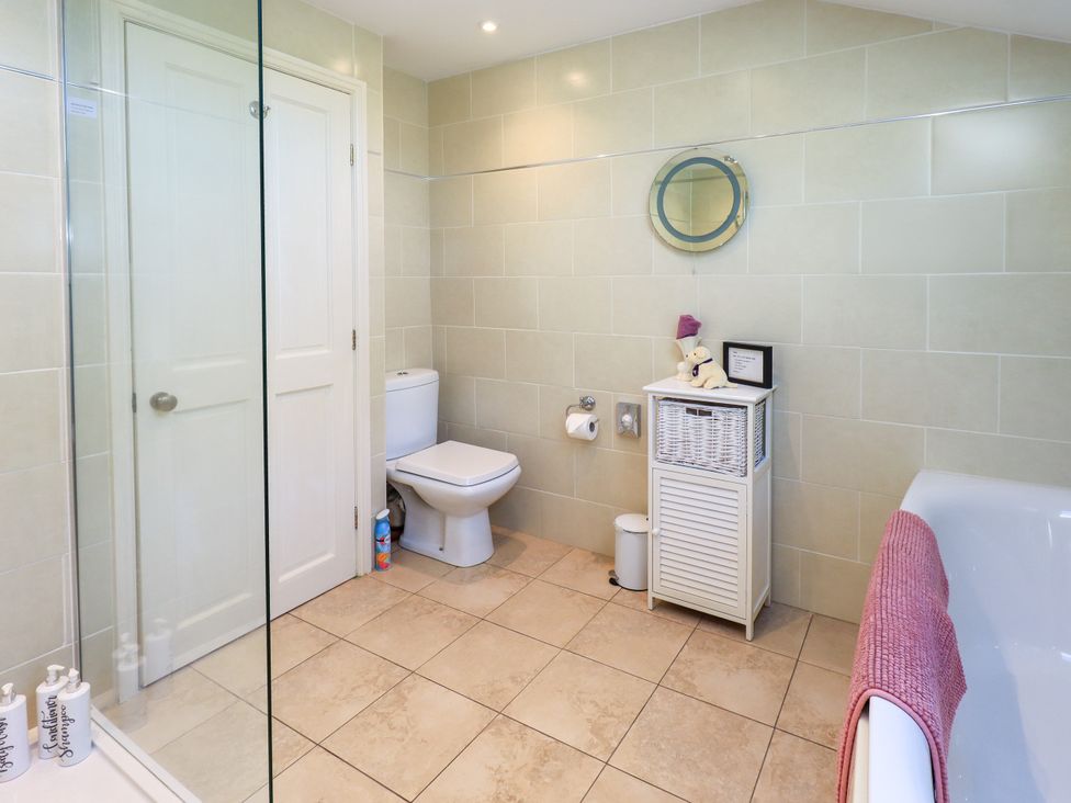 A bathroom with a shower and toilet at The Garden Suite at Fiddler Hall Barn, Newby Bridge