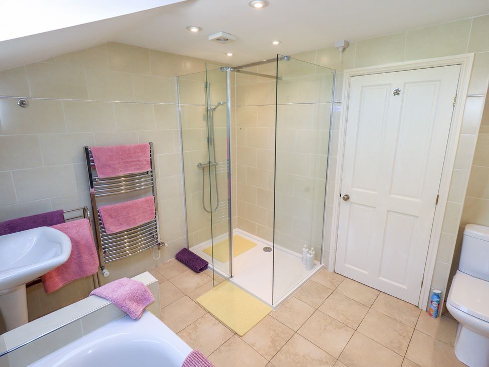 A bathroom with a shower, sink, and bathtub at The Garden Suite at Fiddler Hall Barn Newby Bridge