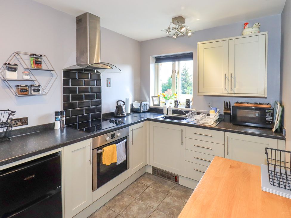 A kitchen with appliances and a counter at The Garden Suite at Fiddler Hall Barn in Newby Bridge