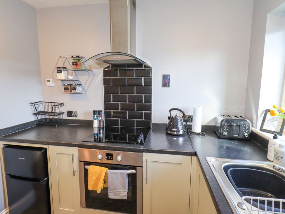 A kitchen with appliances and utensils at The Garden Suite at Fiddler Hall Barn Newby Bridge