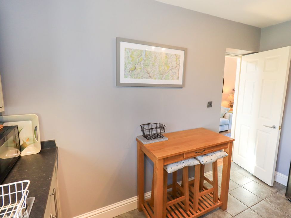 A kitchen with a table and map on the wall at The Garden Suite at Fiddler Hall Barn, Newby Bridge