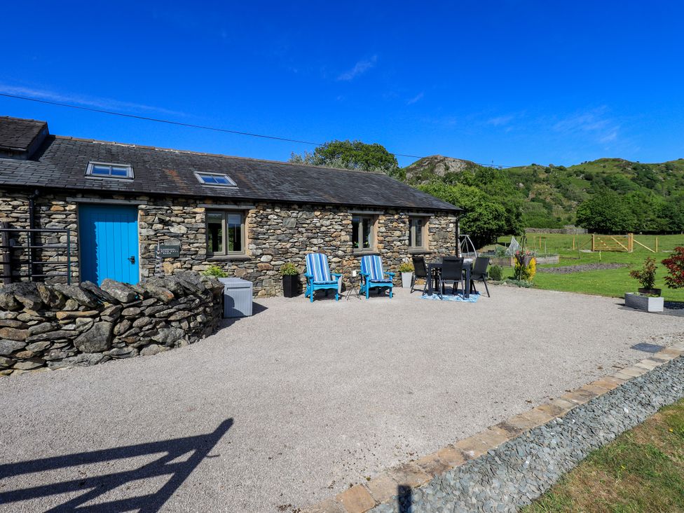 An outdoor area with a stone building and furniture at The Garden Suite at Fiddler Hall Barn Newby Bridge