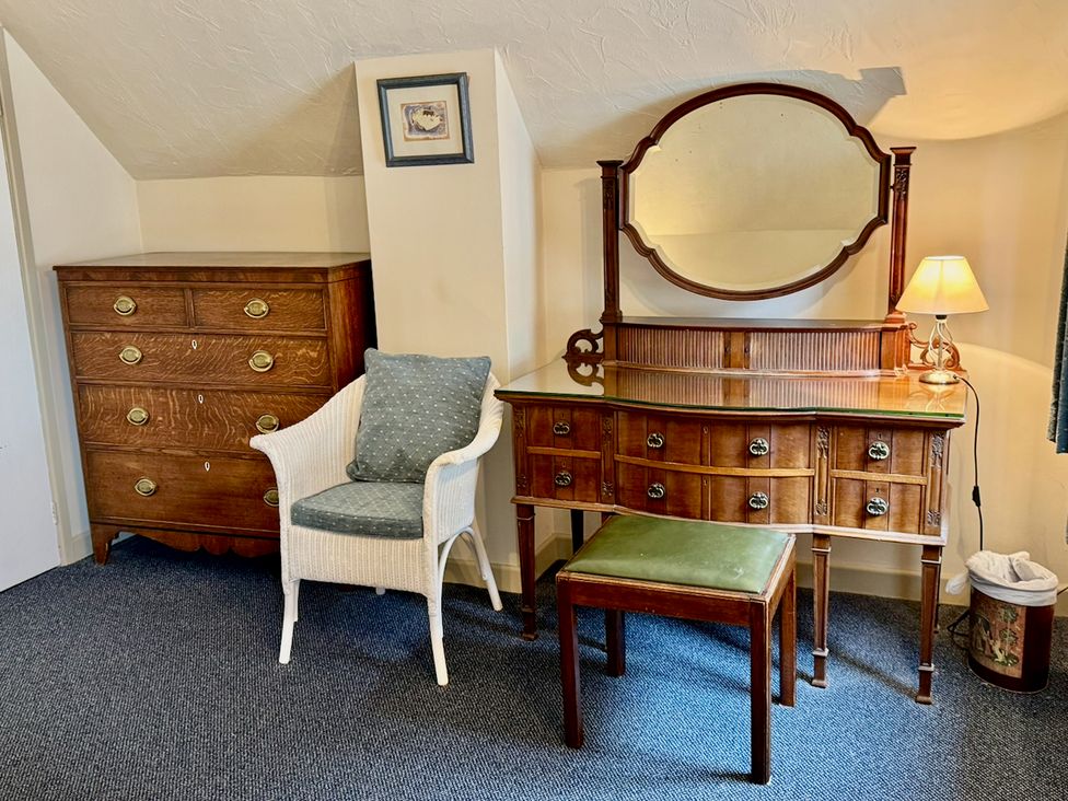 A bedroom with a dressing table and a chest of drawers at Cajun Cottage in West Lulworth